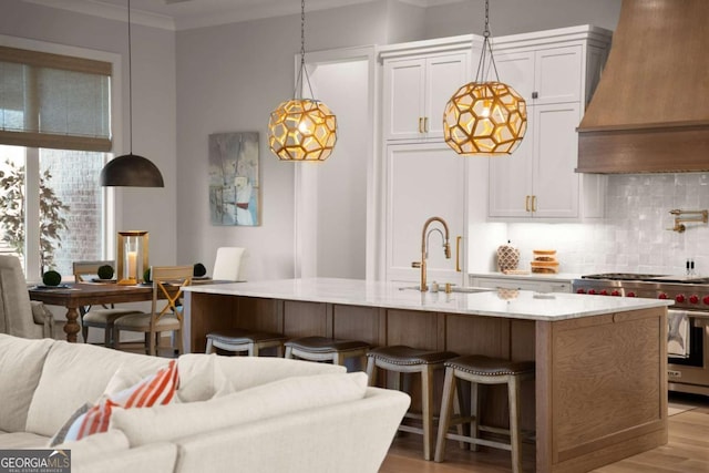 kitchen with luxury range, a sink, tasteful backsplash, crown molding, and custom exhaust hood