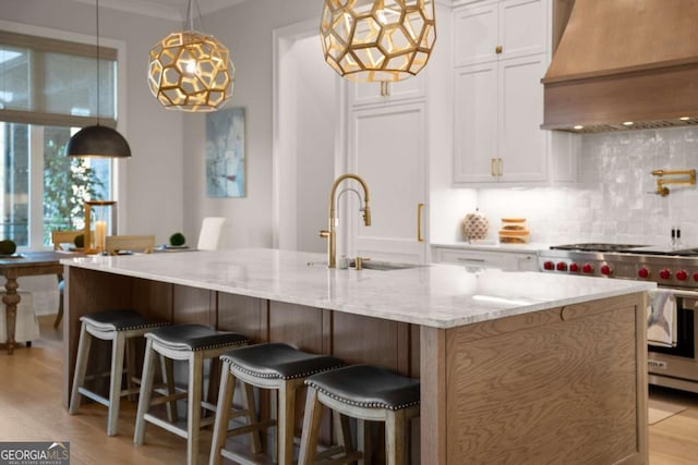 kitchen with backsplash, luxury range, white cabinets, and custom range hood
