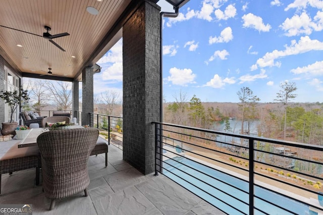 balcony featuring a water view and a ceiling fan