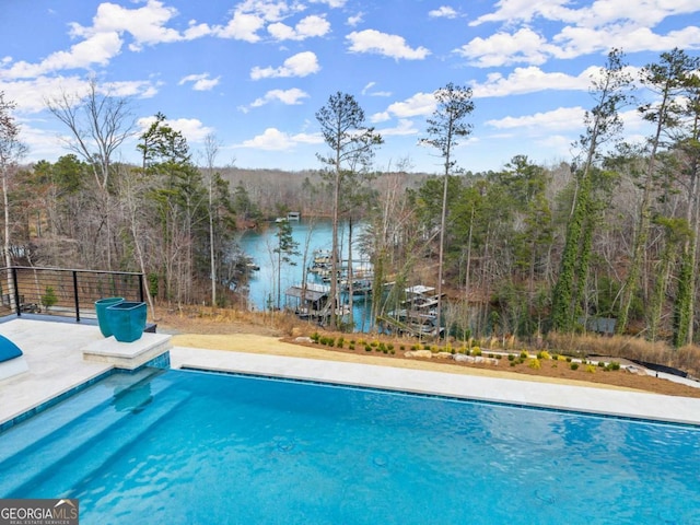 view of swimming pool with a fenced in pool, a view of trees, and a water view