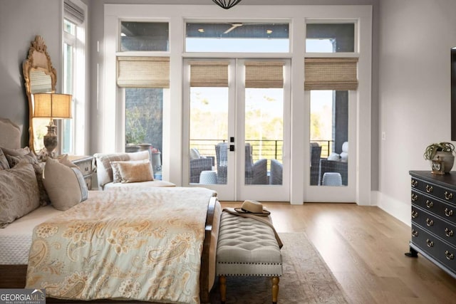 bedroom with french doors, wood finished floors, and access to exterior