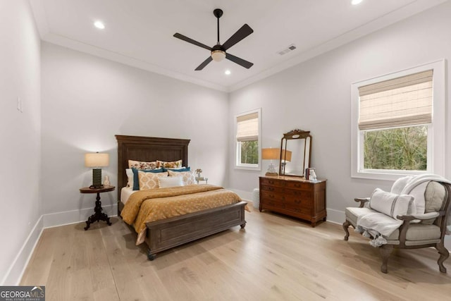 bedroom with crown molding, light wood-style floors, visible vents, and baseboards