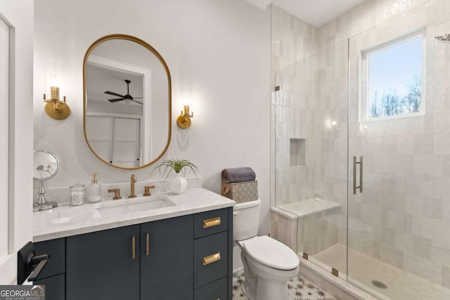 full bathroom with vanity, a shower stall, toilet, and a ceiling fan