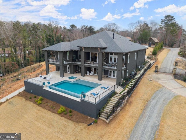 back of property featuring a fenced in pool, a patio, a balcony, and fence