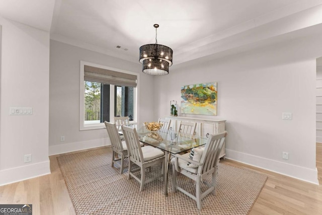dining room featuring an inviting chandelier, light wood-style flooring, and baseboards