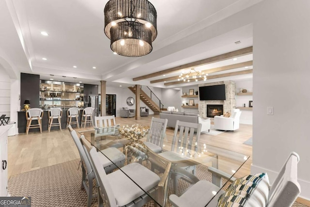 dining area featuring recessed lighting, a notable chandelier, wood finished floors, and a fireplace