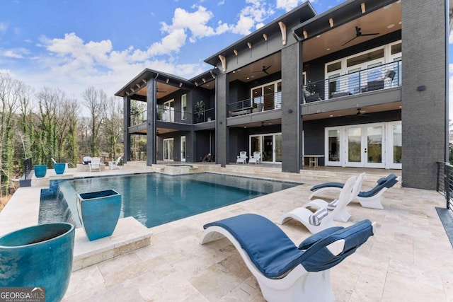view of swimming pool featuring a ceiling fan, a patio, french doors, and a pool with connected hot tub