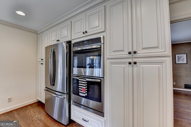 kitchen featuring stainless steel appliances, baseboards, and dark wood-style floors