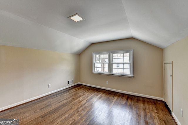 bonus room featuring visible vents, lofted ceiling, baseboards, and wood finished floors