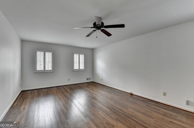 unfurnished room featuring baseboards, wood finished floors, visible vents, and ceiling fan