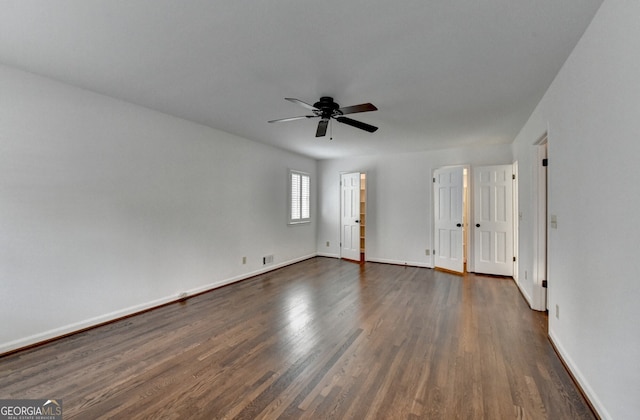 unfurnished room with baseboards, dark wood-style flooring, and ceiling fan