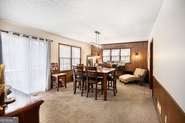 dining area with wooden walls and light carpet