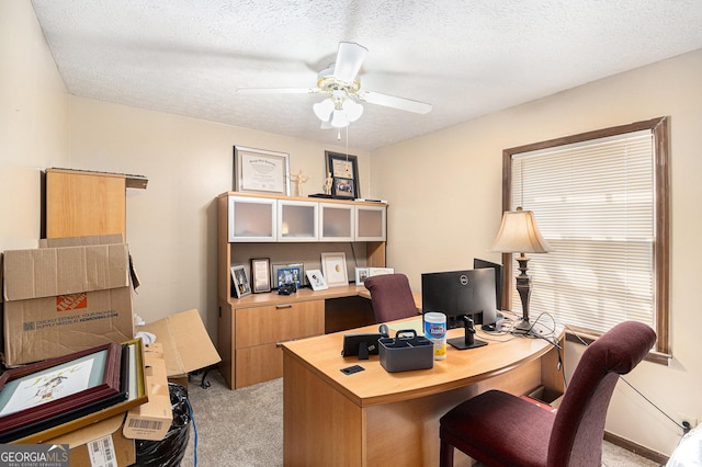 office area with light colored carpet, a ceiling fan, and a textured ceiling