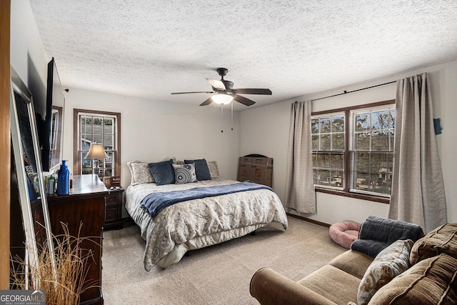 bedroom featuring baseboards, a textured ceiling, a ceiling fan, and carpet