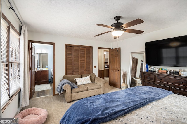 bedroom featuring multiple windows, a textured ceiling, and carpet flooring