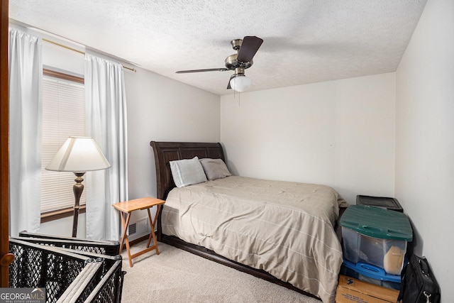 bedroom featuring carpet flooring, a textured ceiling, and a ceiling fan