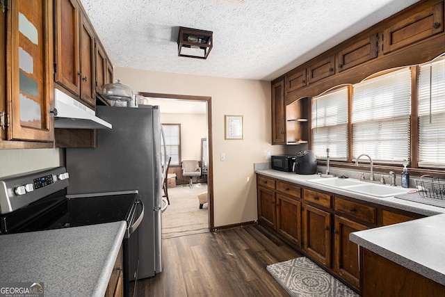 kitchen with under cabinet range hood, stainless steel range with electric cooktop, a wealth of natural light, and a sink