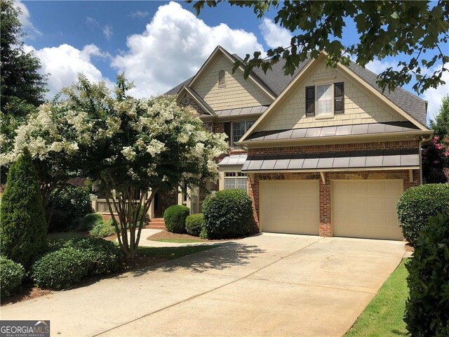 2741 Willowstone Dr, Duluth, GA 30096 - craftsman house featuring concrete driveway, a standing seam roof, roof with shingles, brick siding, and a garage