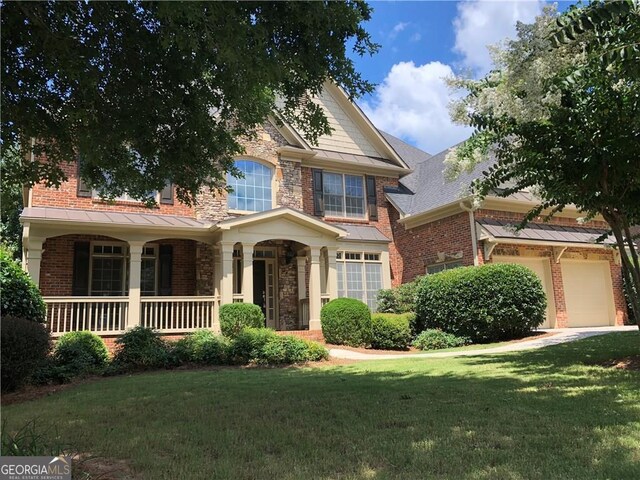 2741 Willowstone Dr, Duluth, GA 30096 - view of front of property with a front yard, covered porch, stone siding, and brick siding