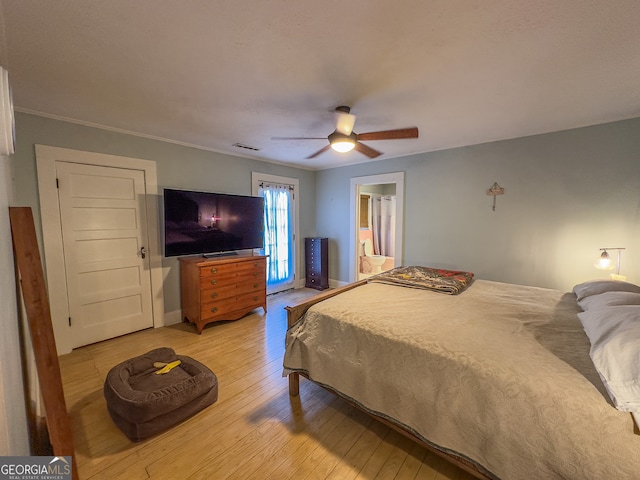 bedroom with visible vents, ornamental molding, light wood finished floors, baseboards, and ceiling fan