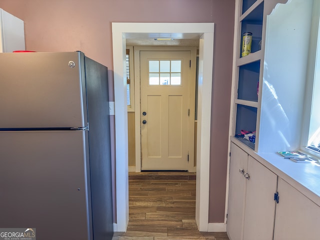 kitchen featuring white cabinetry, light countertops, wood finished floors, and freestanding refrigerator