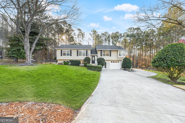 split foyer home with a front lawn, an attached garage, driveway, and a chimney