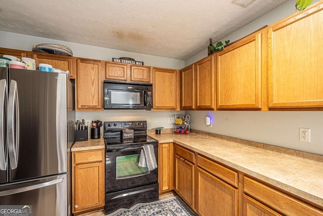 kitchen featuring brown cabinets, a textured ceiling, black appliances, and light countertops