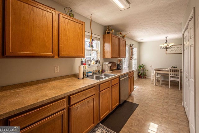 kitchen featuring a sink, brown cabinets, an inviting chandelier, and stainless steel dishwasher