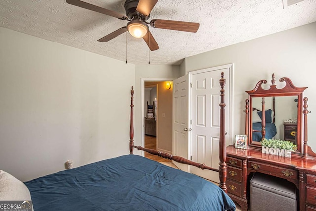 bedroom with a ceiling fan and a textured ceiling