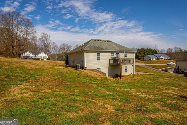 view of home's exterior featuring a lawn and a deck