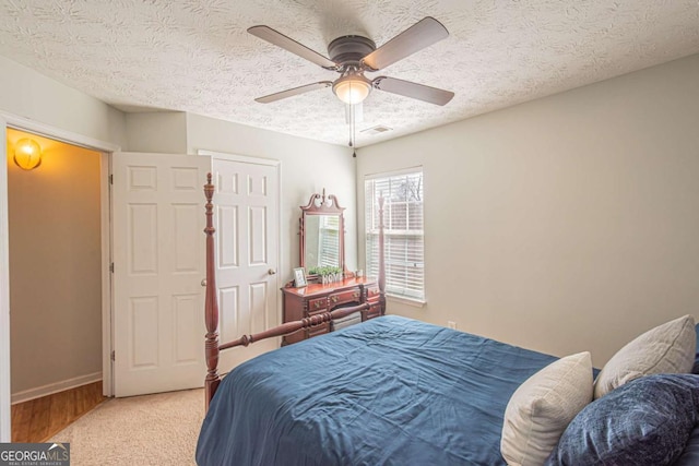 bedroom featuring visible vents, a textured ceiling, a ceiling fan, and baseboards