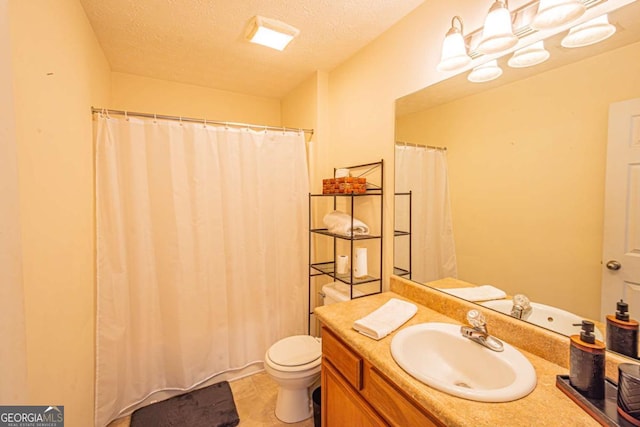 full bathroom with vanity, toilet, and a textured ceiling