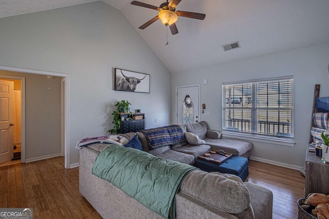 living area with visible vents, high vaulted ceiling, wood finished floors, baseboards, and ceiling fan