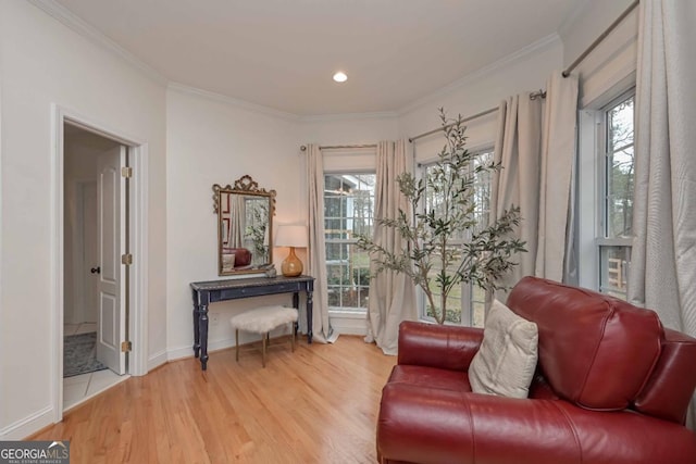 living area with light wood-style floors, baseboards, and ornamental molding