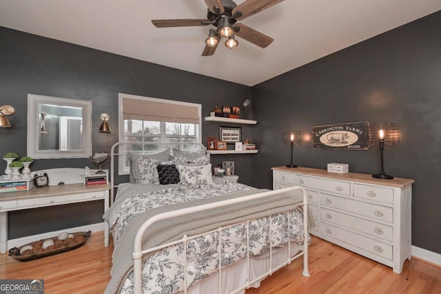 bedroom featuring light wood-type flooring, baseboards, and a ceiling fan