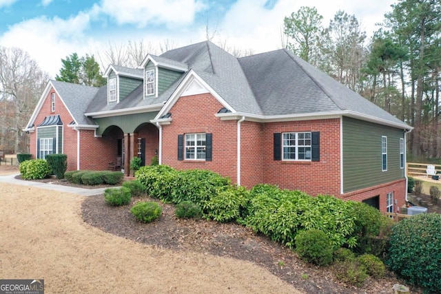 traditional home featuring brick siding and roof with shingles