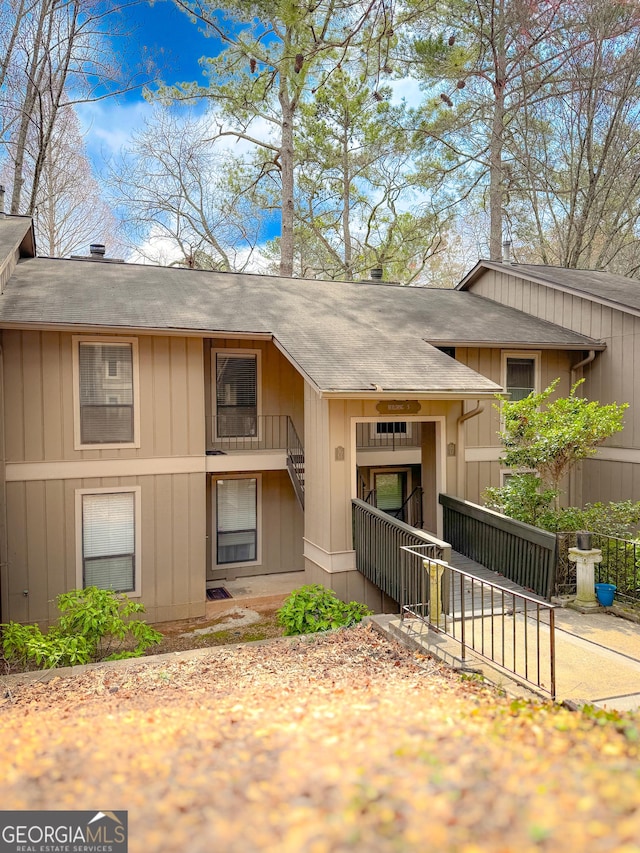 view of front of house with a fenced front yard and a shingled roof