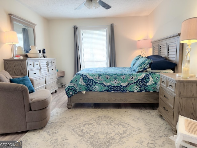 bedroom with light wood finished floors and a textured ceiling