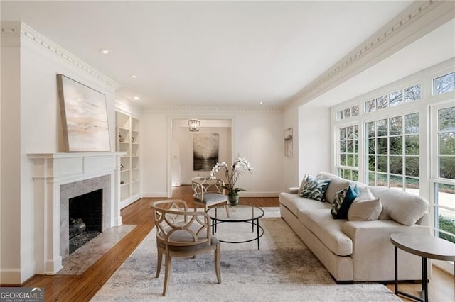 living room with built in shelves, wood finished floors, recessed lighting, a fireplace, and baseboards