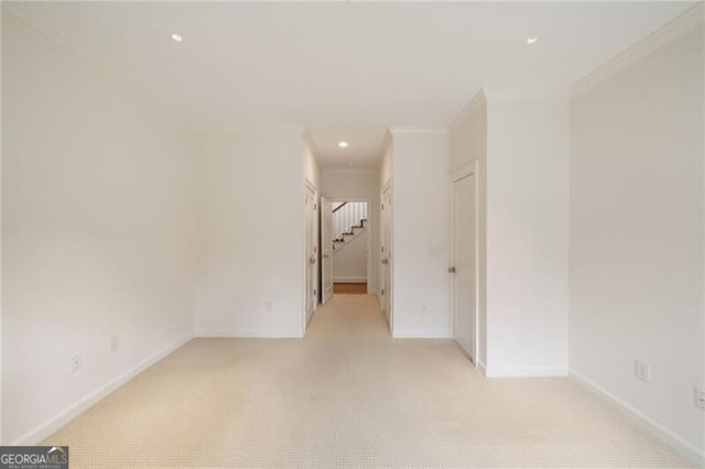 unfurnished room featuring recessed lighting, light colored carpet, crown molding, and baseboards