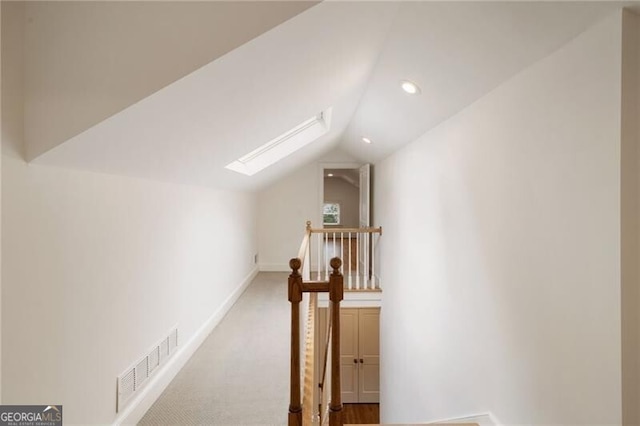 additional living space featuring visible vents, recessed lighting, vaulted ceiling with skylight, carpet flooring, and baseboards