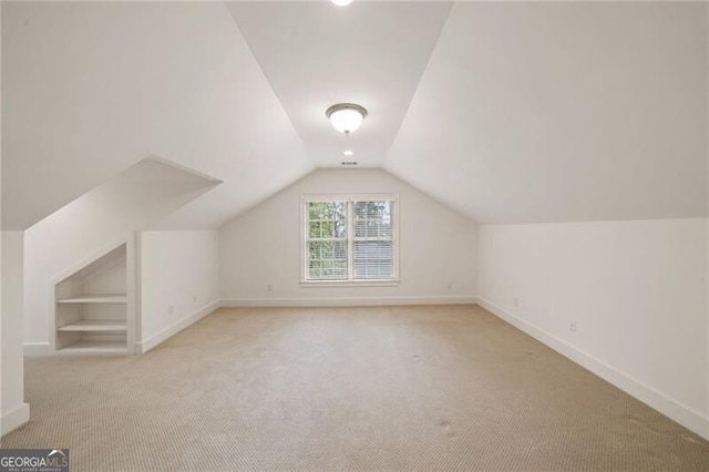 bonus room with built in features, baseboards, carpet, and vaulted ceiling