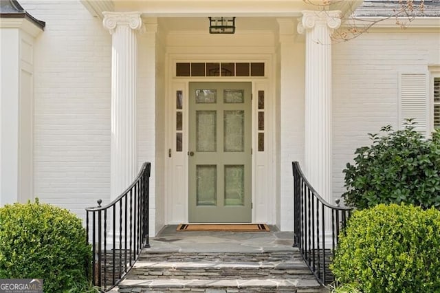 doorway to property featuring brick siding