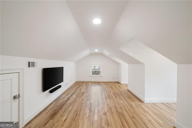 bonus room featuring lofted ceiling, light wood-style flooring, baseboards, and visible vents