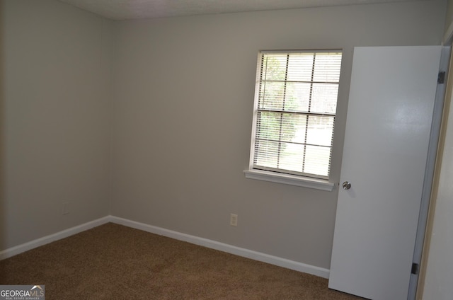 carpeted spare room with baseboards