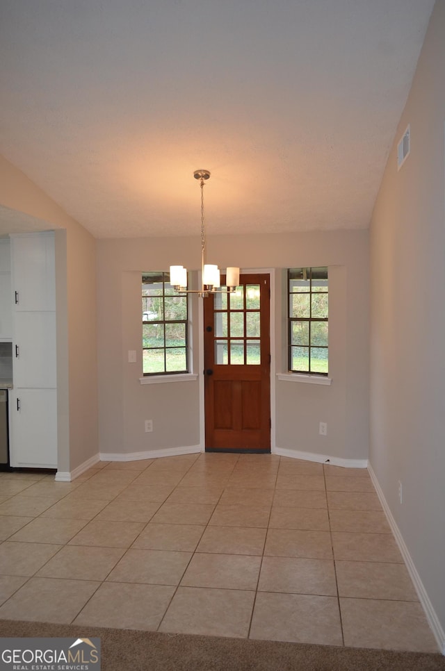 interior space featuring light tile patterned floors, visible vents, baseboards, and a notable chandelier