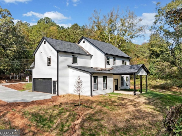 back of house featuring an attached garage, a yard, driveway, and a shingled roof