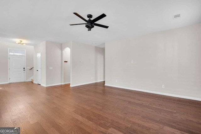 unfurnished living room with ceiling fan, visible vents, baseboards, and wood finished floors