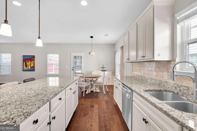 kitchen with dark wood-type flooring, a sink, white cabinets, decorative backsplash, and dishwasher