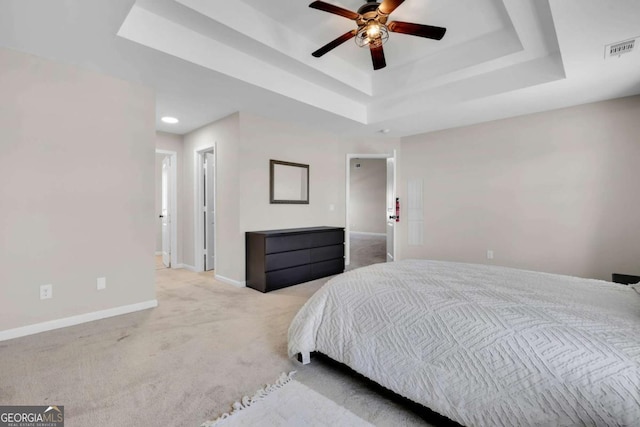 bedroom featuring visible vents, ceiling fan, baseboards, carpet, and a tray ceiling